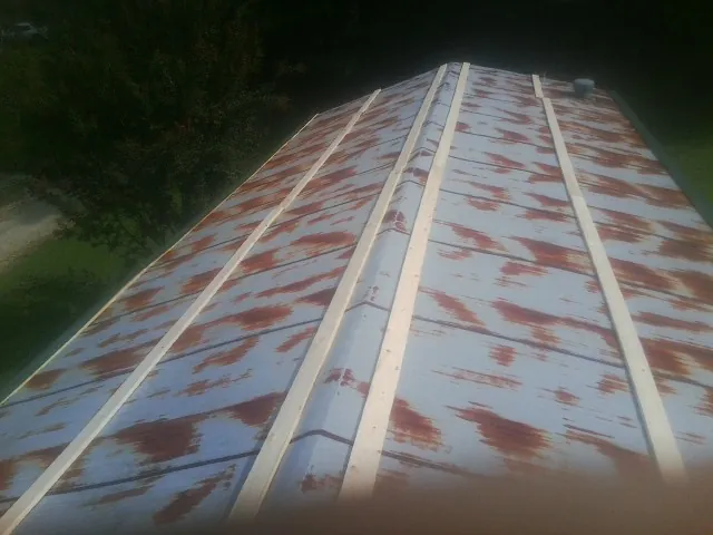 Rusted metal roof panels with new wood purlins before replacement — Storm Damage Roof Repair in Haralson by Roofing Brothers