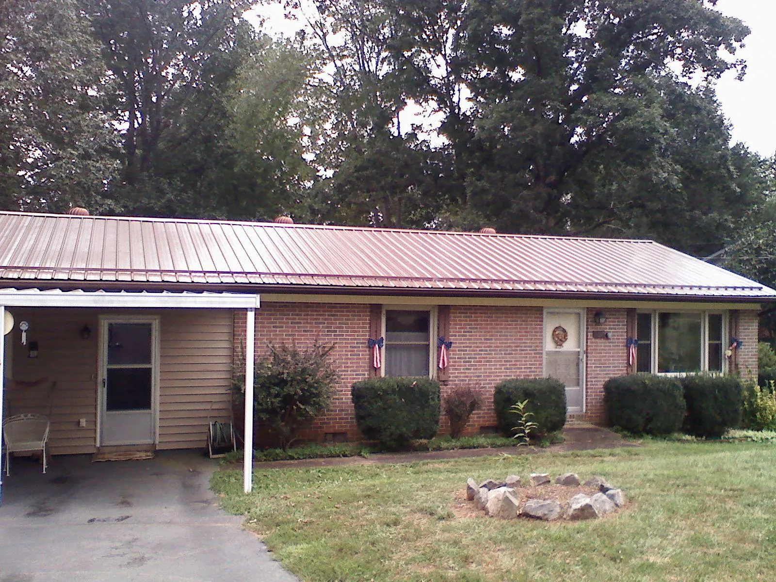 Bronze metal roof and carport on a brick ranch home — Roof Repair work by our crew in Haralson